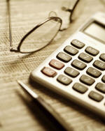 Photo of pen, glasses and calculator on a newspaper